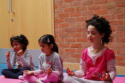 Photo of young children meditating during yoga class